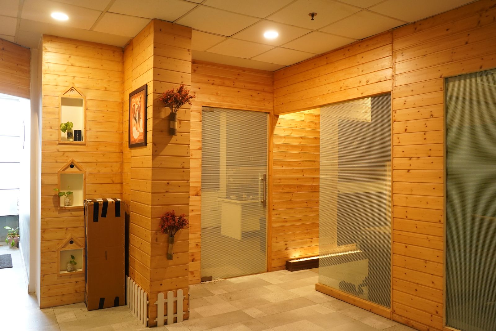 A timber panelled office interior with glass doors and warm lighting