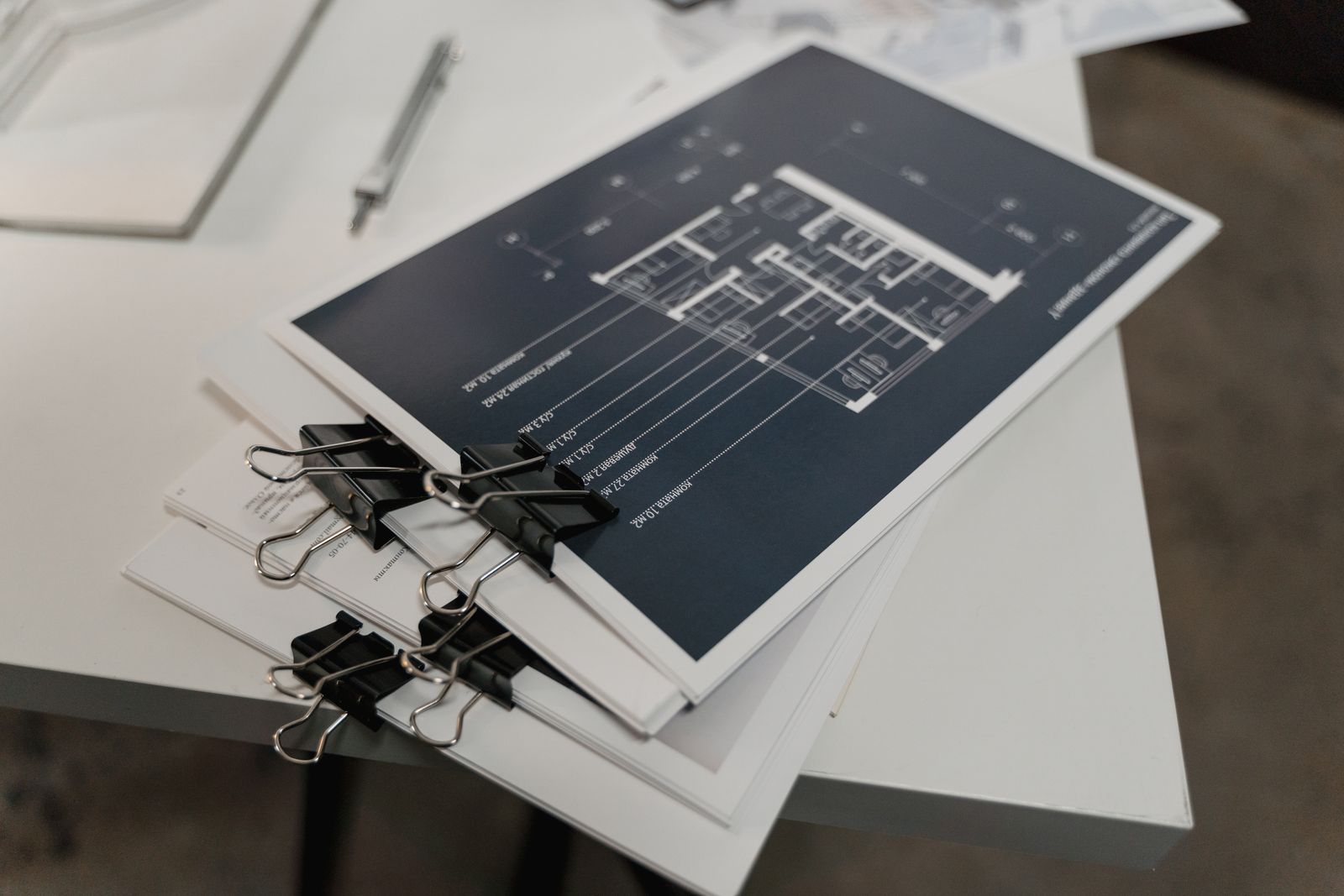 A stack of architectural floor plans held with clips
